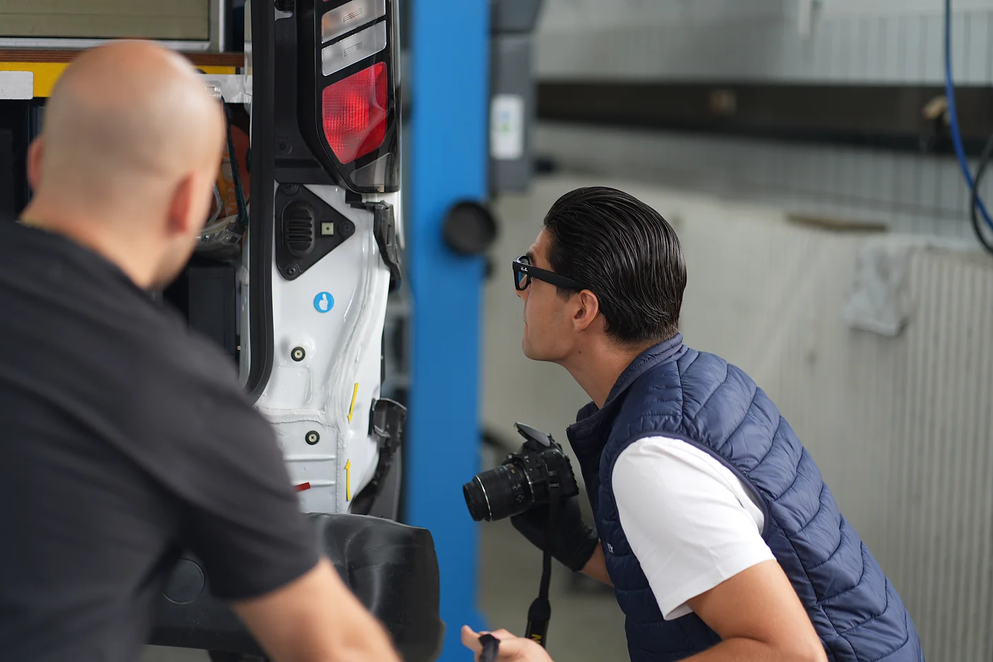 Der Kunde ist dabei, während Davide Balsamello den Heckschaden seines Fahrzeugs fotografiert