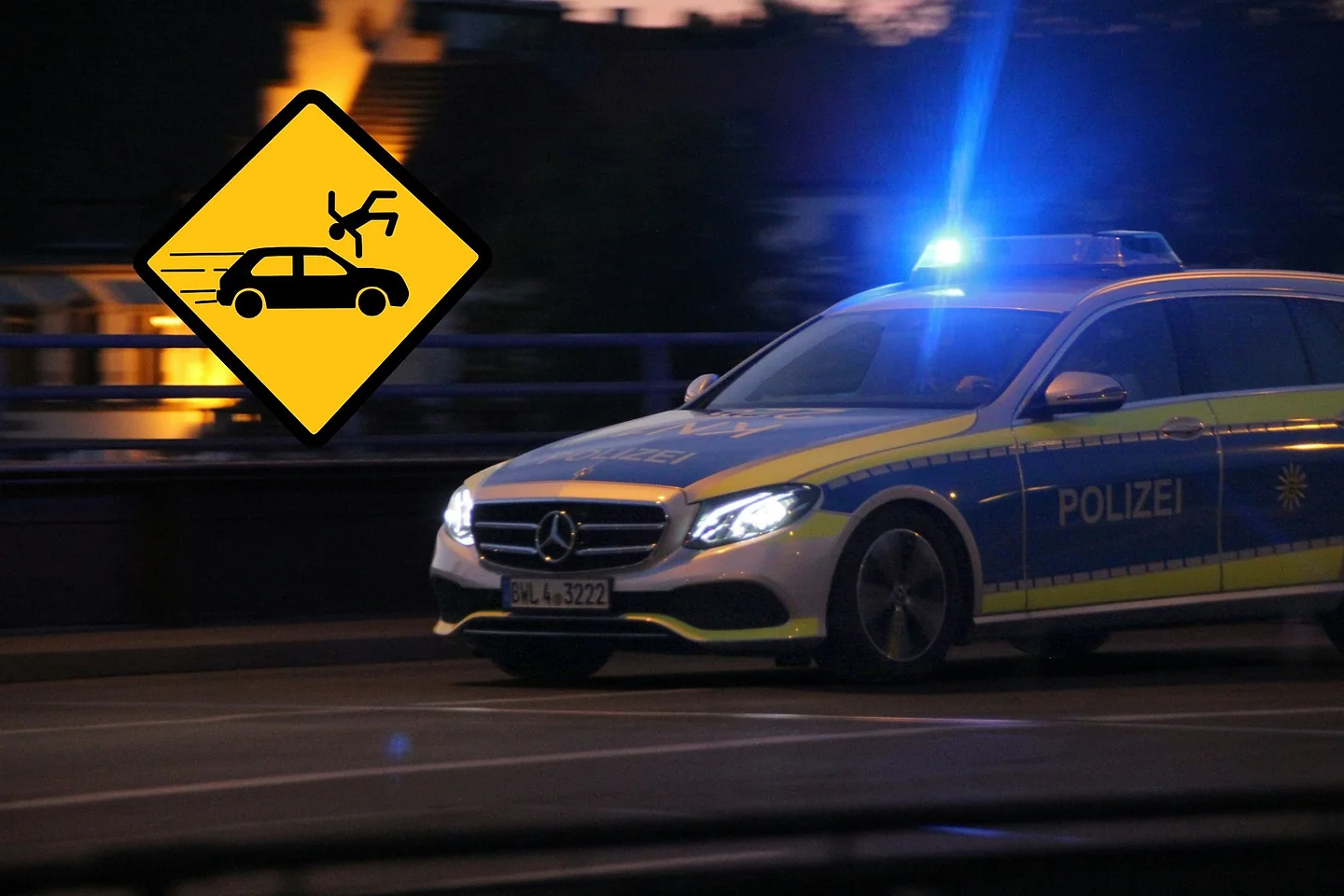 Polizeiwagen mit Blaulicht bei Nacht, daneben ein gelbes Warnschild